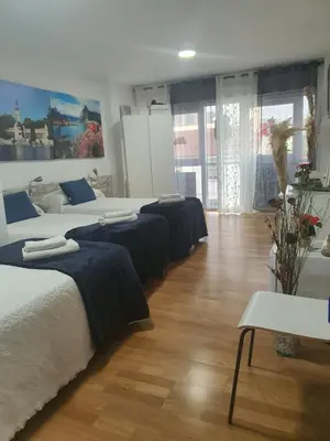 a room with four beds with blue sheets on them at Pension Myriam O PEDROUZO in O Pedrouzo