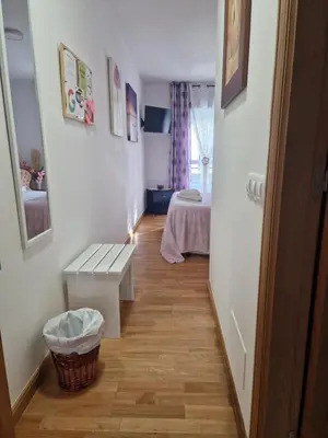 a hallway with a bench and a bed in a room at Pension Myriam O PEDROUZO in O Pedrouzo