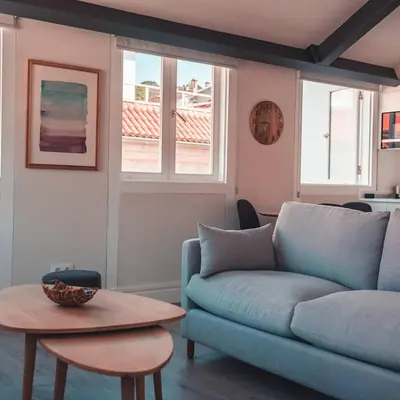 a living room with a blue couch and a table at Apartamentos Pontedeume Riadoeume in Puentedeume