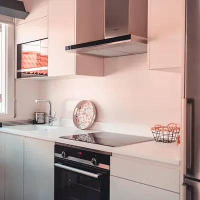 a kitchen with white cabinets and a black stove top oven at Apartamentos Pontedeume Riadoeume in Puentedeume
