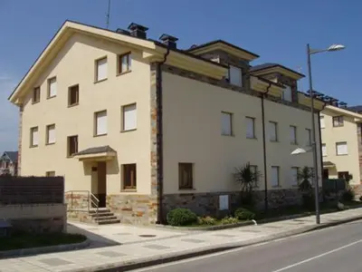 a large white building on the side of a street at Apartamento Faro de Tapia in Tapia de Casariego