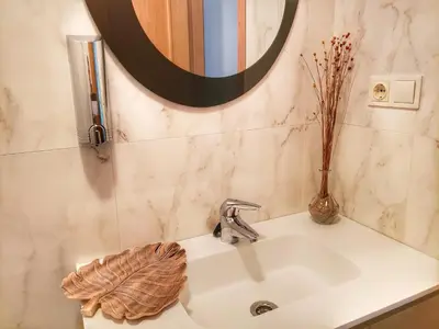 a bathroom sink with a vase and a mirror at Santiago Sur, Camino Portugués in Milladoiro