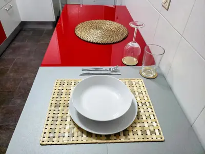 a table with a white plate and a red table at Santiago Sur, Camino Portugués in Milladoiro