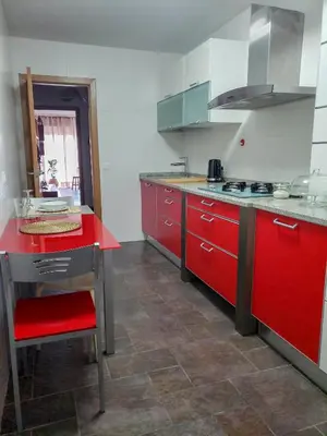 a kitchen with red cabinets and a red counter top at Santiago Sur, Camino Portugués in Milladoiro