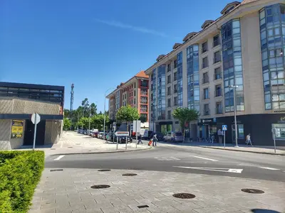 an empty street in a city with tall buildings at Santiago Sur, Camino Portugués in Milladoiro
