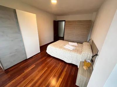 a bedroom with a bed and a wooden floor at Apartamento Bralo in Padrón