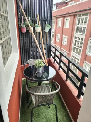 a balcony with a table and chairs and plants at Apartamento Puerto de Foz in Foz