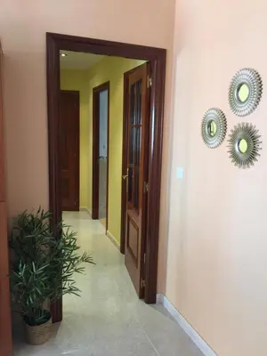a hallway with two mirrors on the wall and a door at Apartamento Puerto de Foz in Foz