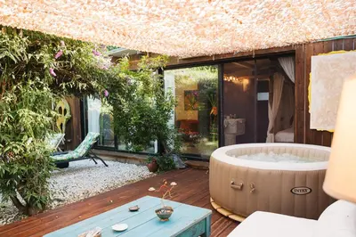 a large tub sitting on a deck with a garden at Maxia Galega -Arte, Natureza, Relax -Ribeira Sacra in Monforte de Lemos