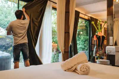 a man is opening a curtain in a room at Maxia Galega -Arte, Natureza, Relax -Ribeira Sacra in Monforte de Lemos