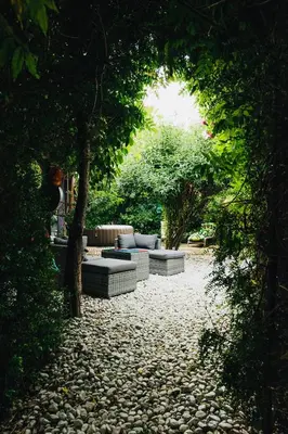 a garden with couches and trees on a gravel path at Maxia Galega -Arte, Natureza, Relax -Ribeira Sacra in Monforte de Lemos