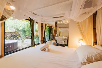 a bedroom with a large white bed with a large window at Maxia Galega -Arte, Natureza, Relax -Ribeira Sacra in Monforte de Lemos