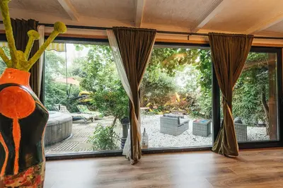 a room with a large window with a view of a garden at Maxia Galega -Arte, Natureza, Relax -Ribeira Sacra in Monforte de Lemos