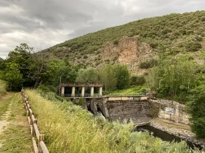 a bridge over a river next to a mountain at La obra de Joaquin, tu rincón en el Bierzo alto in Folgoso de la Ribera