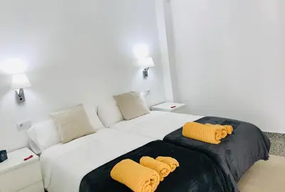 a bedroom with a large bed with two yellow pillows at Apartamento Padron Centro P8 by URent in Padrón