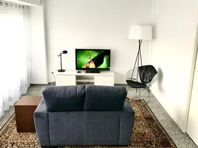 a living room with a blue couch and a tv at Apartamento Padron Centro P8 by URent in Padrón