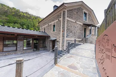 a stone building with a walkway in front of it at Apartamentos Rurales Casa Llongo in Coaña