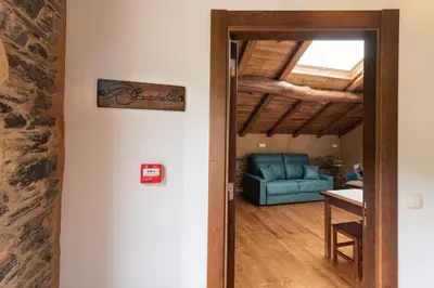 a door leading into a living room with a blue couch at Apartamentos Rurales Casa Llongo in Coaña