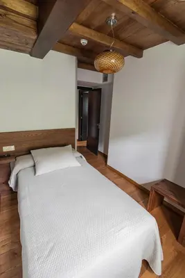 a bedroom with a white bed in a room at Apartamentos Rurales Casa Llongo in Coaña