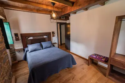 a bedroom with a bed with a blue blanket at Apartamentos Rurales Casa Llongo in Coaña