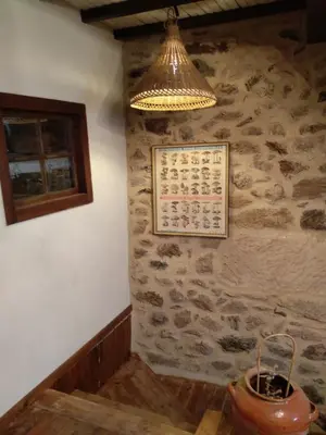a chandelier hanging over a room with a stone wall at Casa Ribeira Sacra, Ourense, Niñodaguia, Galicia in Ourense