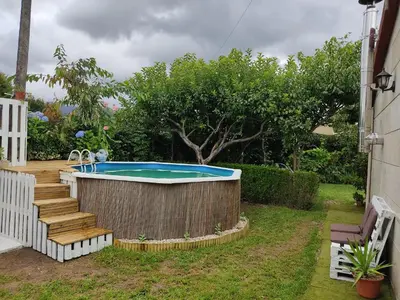 a hot tub in a yard with a wooden fence at A Chabola Mondariz in Pontevedra