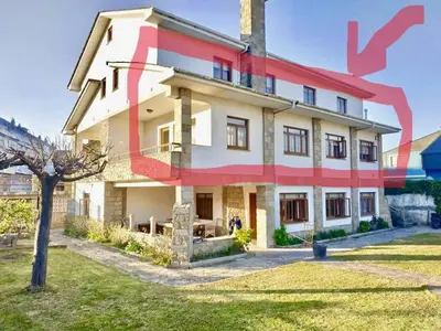 a large house with a red stripe on it at Covas Beach Arena in Viveiro