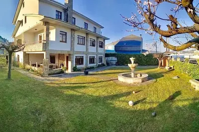a large house with a fountain in the yard at Covas Beach Arena in Viveiro