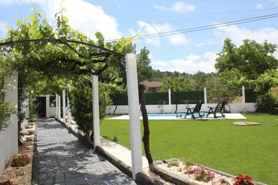 a garden with a pergola and a pool at A Casa de Pia in Sober