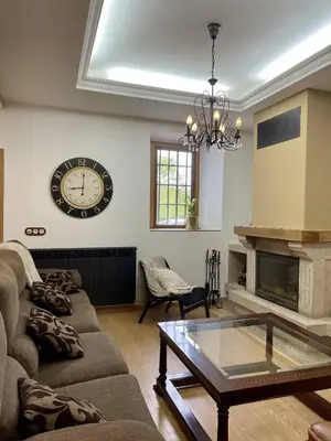 a living room with a couch and a clock on the wall at A Casa de Pia in Sober