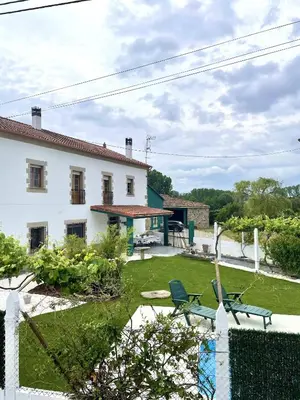 a white house with a yard with two chairs at A Casa de Pia in Sober