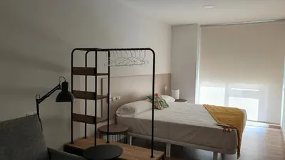 a bedroom with a bed and a metal bunk bed at Apartamentos Antares 3 in Milladoiro
