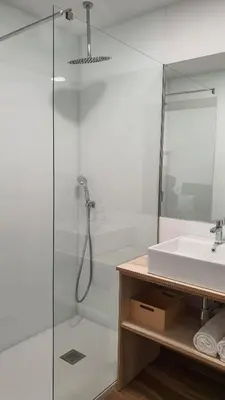 a bathroom with a glass shower and a sink at Apartamentos Antares 3 in Milladoiro