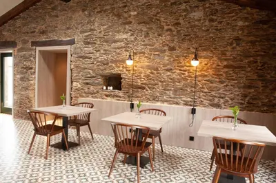 a room with tables and chairs and a brick wall at Casa Rico de Medín in O Pino
