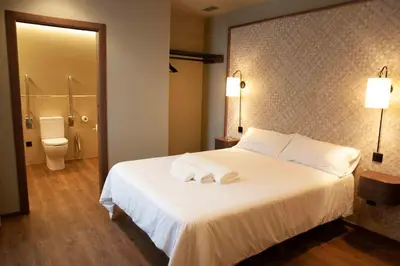 a hotel room with a white bed and a bathroom at Casa Rico de Medín in O Pino
