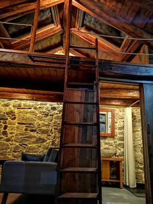 a loft bed in a room with a wooden ceiling at El Cuarto in Suarbol
