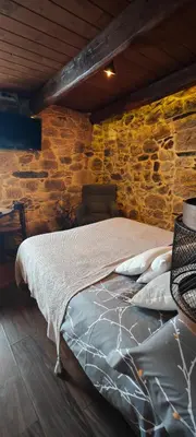 a bed in a room with a stone wall at El Cuarto in Suarbol