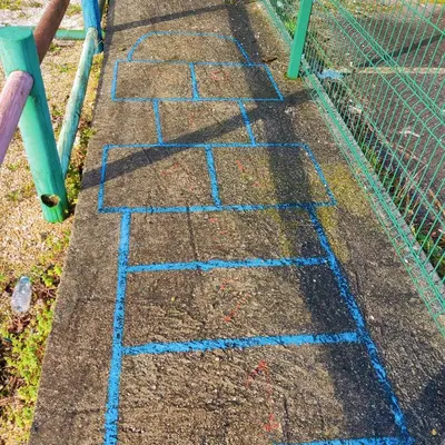 a stone walkway with blue writing on it next to a fence at Eirixo in Valga