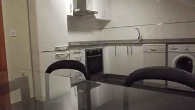 a kitchen with a glass table and two chairs at Figueras 5 in figueras