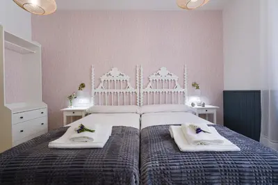 a bedroom with a large bed with towels on it at Pensión Ferradura in Melide