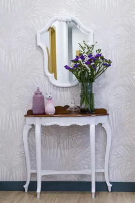 a vase of flowers on a table with a mirror at Pensión Ferradura in Melide
