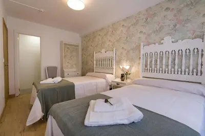a bedroom with two beds and two tables with towels at Pensión Ferradura in Melide