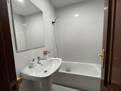 a white bathroom with a sink and a bath tub at Altamira in Caldas de Reis