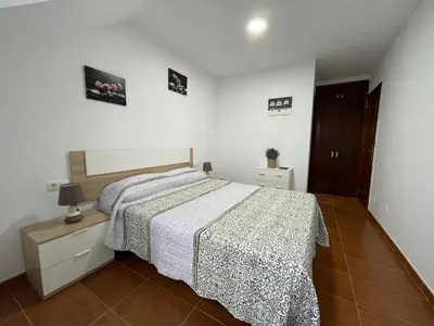 a bedroom with a large bed and a nightstand with a bedspread at Altamira in Caldas de Reis