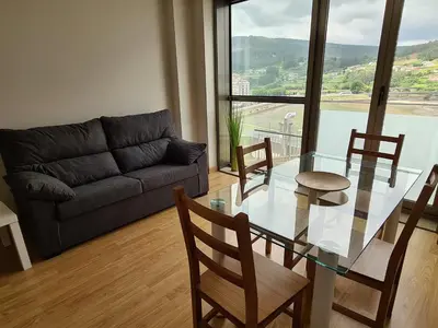 a living room with a glass table and a couch at APARTAMENTOS VIVE in Viveiro