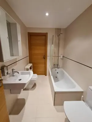a bathroom with two sinks and a tub and a toilet at APARTAMENTOS VIVE in Viveiro