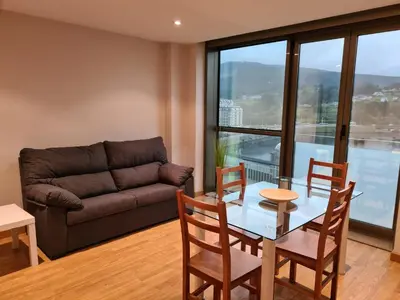 a living room with a table and chairs and a couch at APARTAMENTOS VIVE in Viveiro