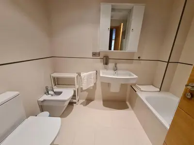 a bathroom with a toilet and a sink and a tub at APARTAMENTOS VIVE in Viveiro