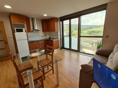 a living room with a table and a kitchen at APARTAMENTOS VIVE in Viveiro