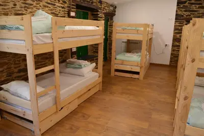 two bunk beds in a room with wooden floors at Eco dos Teixos in Casayo